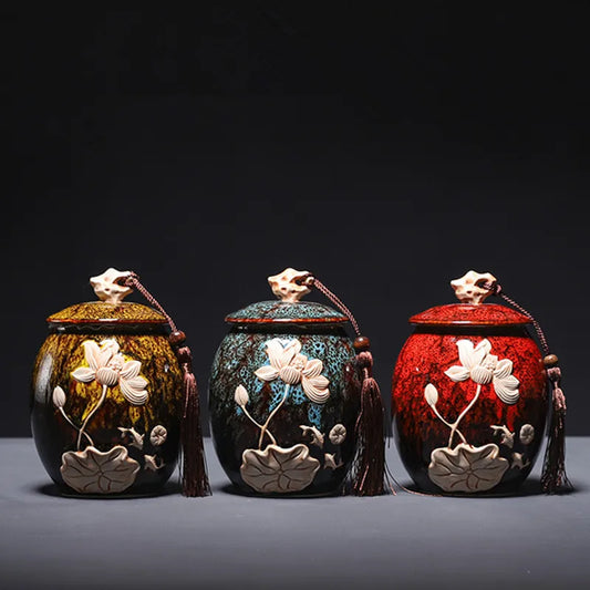 Three ornate ceramic containers with floral designs on a dark background