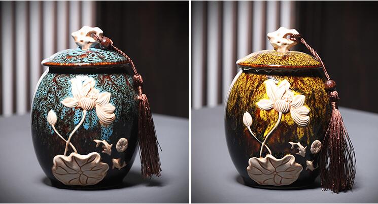 Two ceramic jars with floral designs and tassels on a gray background