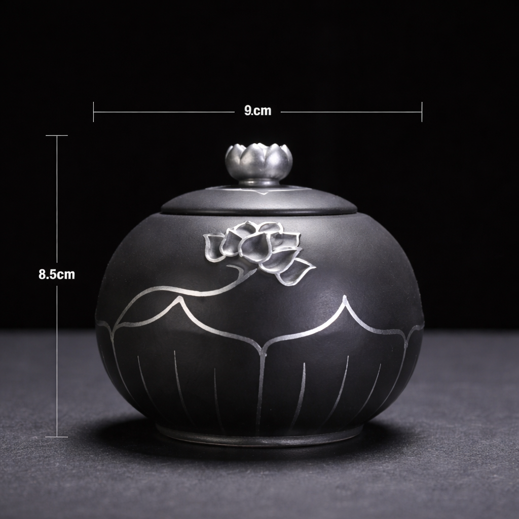 Black ceramic container with silver floral design and lid, shown with measurements on a dark background.