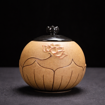 Ceramic container with lotus flower design on a black background